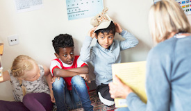 En förskolelärare har högläsning för fyra barn