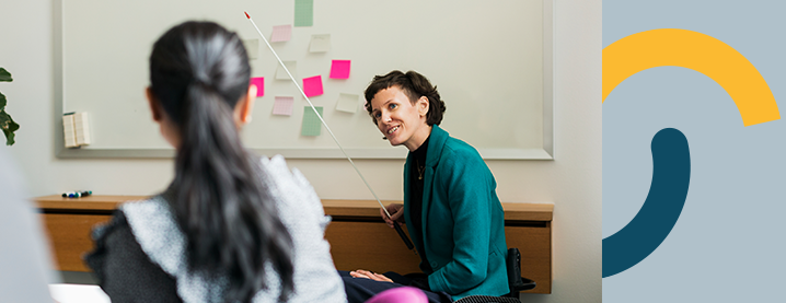 Klassrum med skärpan på en kvinnlig lärare, i förgrunden en flicka. Flickan är oskarp.