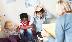 En förskolelärare har högläsning för fyra barn