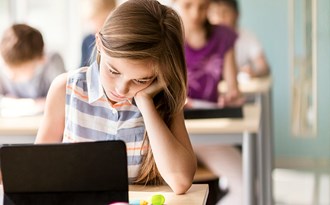 En elev sitter fokuserad under en lektion och studerar
