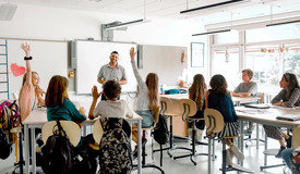 En lärare står och undervisar en mellanstadieklass i ett klassrum