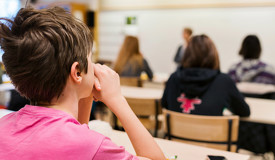 En högstadieklass lyssnar under en lektion