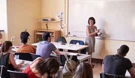 Lärare undervisar klass vid en whiteboard-tavla