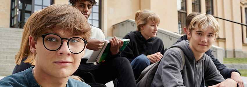 © En grupp gymnasieelever sitter på en trappa
