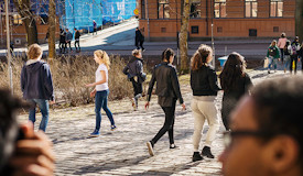 Gymnasieelever går utomhus i solen