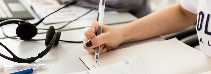 © En närbild på ett anteckningsblock som en skriver i